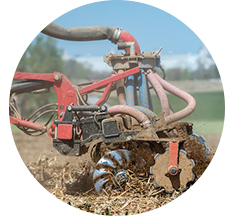 A red manure injector working in a field, image copyright Edwin Remsberg